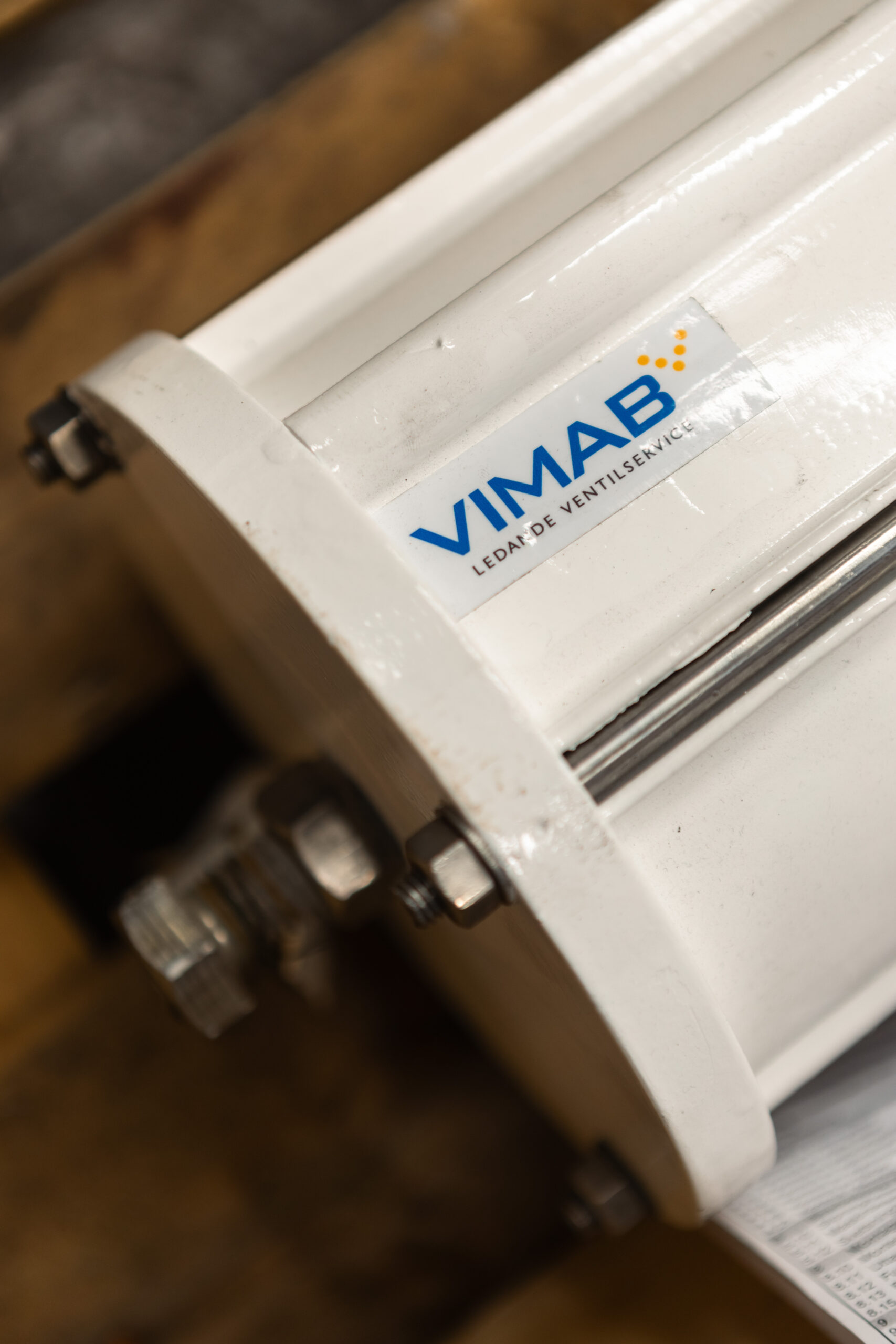 VIMAB-logotype på ventil i verkstadsmiljö med metalldetaljer och anslutningar synliga