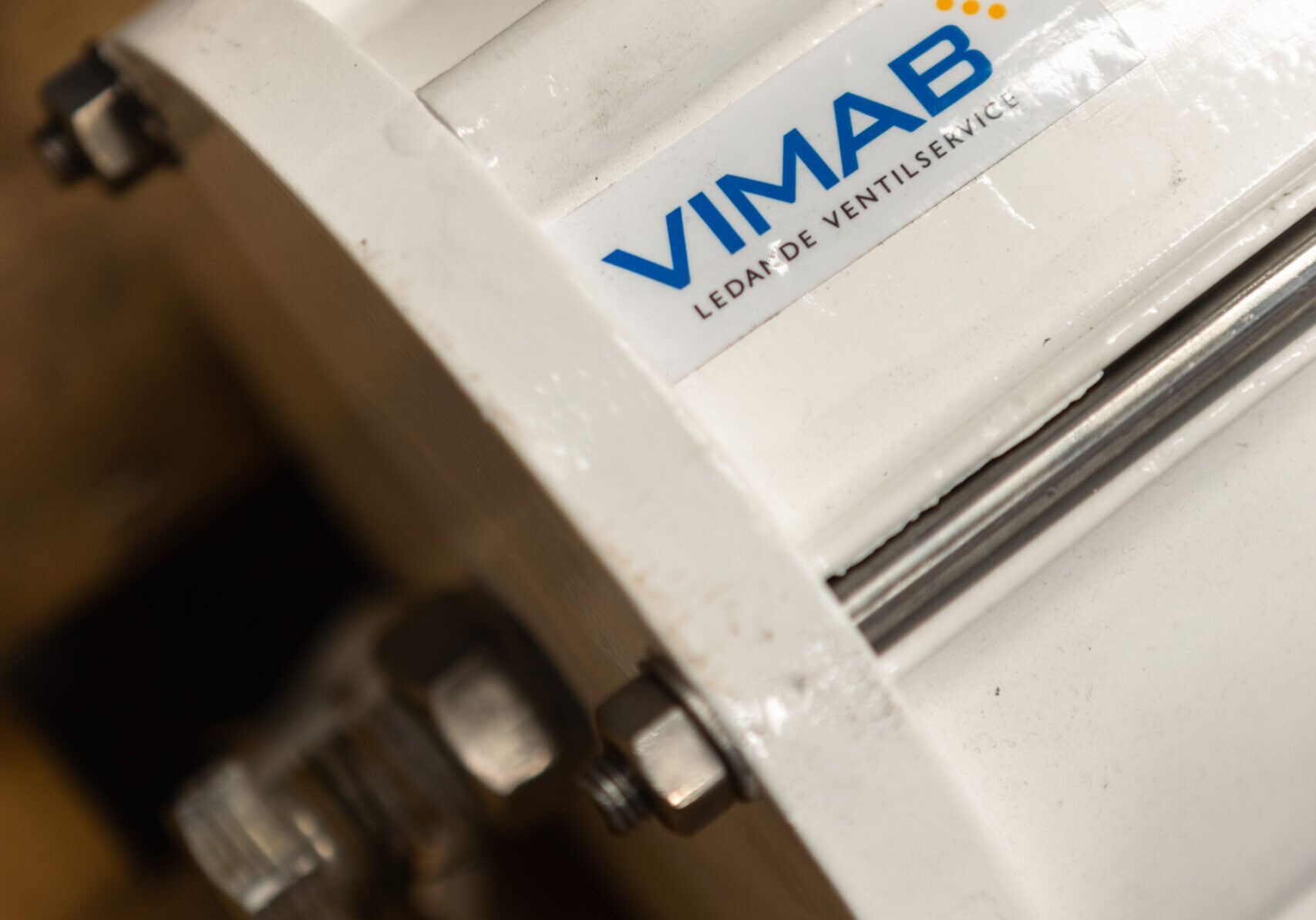 VIMAB-logotype på ventil i verkstadsmiljö med metalldetaljer och anslutningar synliga