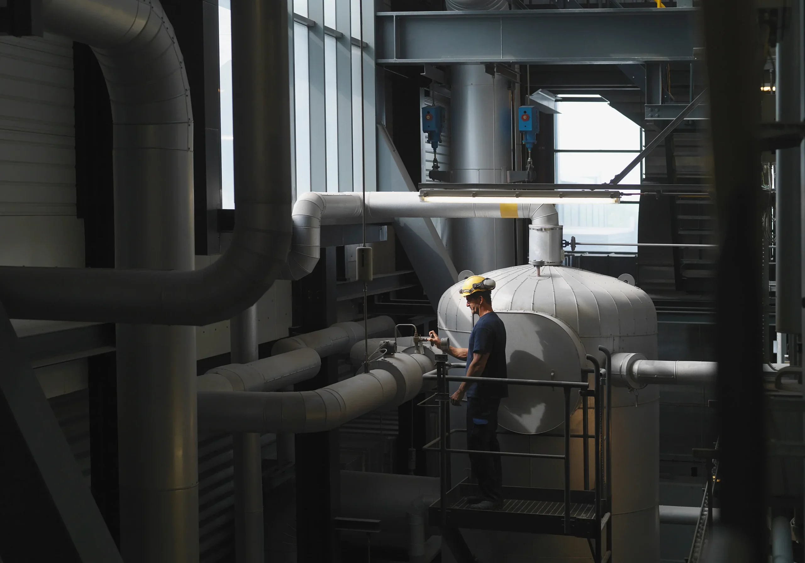 Ventiltekniker med hjälm och skyddsglasögon utför funktionskontroll på rörledningar i processindustrianläggning